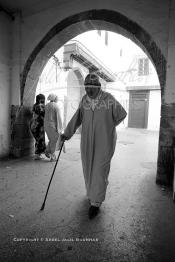 Image du Maroc Professionnelle de  Dans une rue des Habous, la succession des balèvres, moulure, arches, portiques et autres éléments décoratifs, projetent les visiteurs dans l’ardeur avec un élan de force et de fierté d’une époque révolue. Conçu par les architectes Auguste Cadet et Edmond Brion d’après l’ébauche d’un premier plan-masse dû à Albert Laprade, le quartier fait partie des endroits les plus pittoresques de Casablanca, il fut La construction n’avait commencé qu’après la première guerre mondiale. Situé près du Palais Royale, ce joyau architectural fait partie du patrimoine architectural de la ville, Samedi 8 Novembre 2008. Au centre le minaret de La mosquée Ben Youssef. (Photo / Abdeljalil Bounhar)
